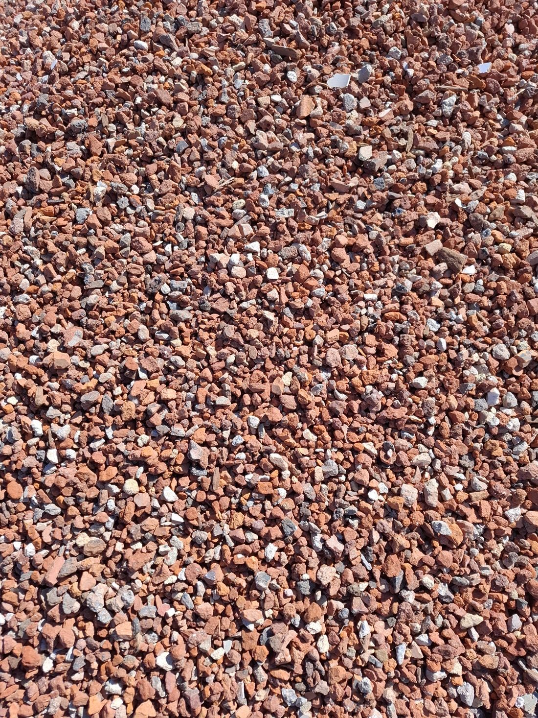 Red Crushed Brick (20mm) close up, supplied and delivered across Perth by Red Sand Supplies